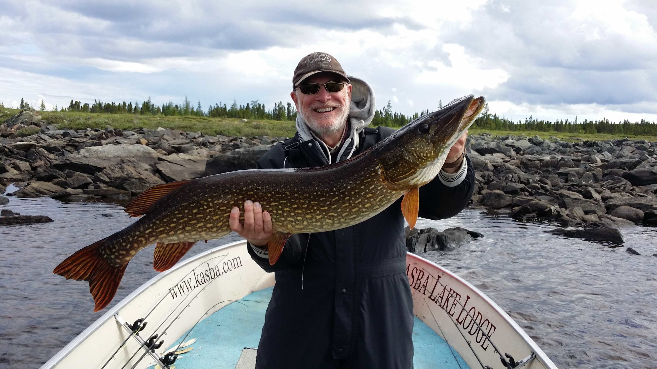 man with a big fish in boat at kasba lake lodge